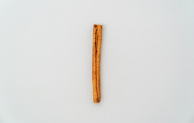 Cinnamon stick on light gray background with copy space