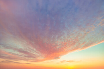 A beautiful sky tinted by the sun leaving vibrant shades of gold, pink, blue and multicolored. Clouds in the twilight evening and morning sky. Cloudy sky background in the evening and during the day.