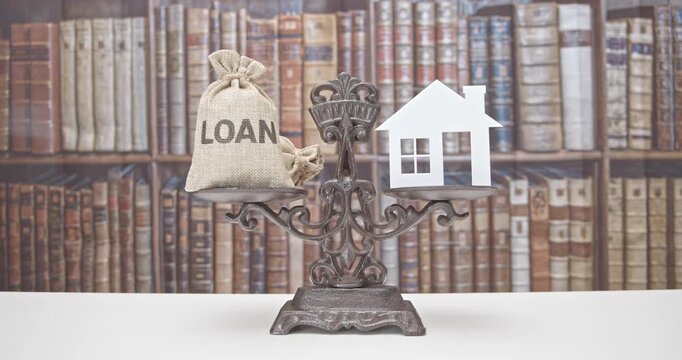 Home loan, reverse mortgage and saving for a real estate concept : House model, loan bag on a balance scale, depicts saving for a house or flat manageable and make a dream of owning a home come true.