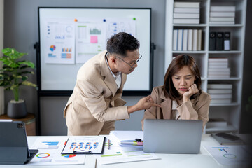 A man and a woman are in a meeting room