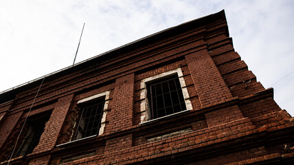 A Beautiful Brick Building Facade Standing Tall Against a Dramatic Cloudy Sky Above