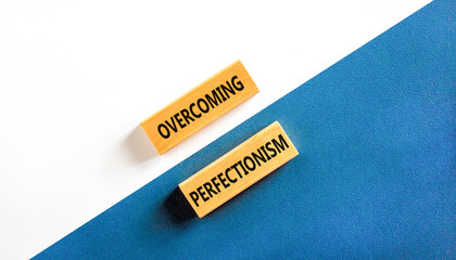 Overcoming perfectionism symbol. Concept words Overcoming perfectionism on beautiful wooden block. Beautiful blue and white paper background. Business Overcoming perfectionism concept. Copy space.