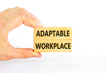 Adaptable workplace symbol. Concept words Adaptable workplace on beautiful wooden block. Beautiful white paper background. Businessman hand. Business Adaptable workplace concept. Copy space.