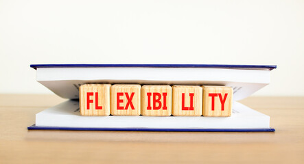 Flexibility symbol. Concept word Flexibility on beautiful wooden cubes in book. Beautiful wooden table white background. Business flexibility concept. Copy space.