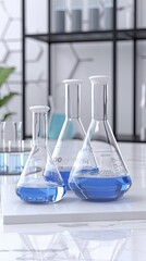 Clear beakers filled with blue liquid are arranged on a white table in a well-lit laboratory filled with scientific equipment and a molecular structure backdrop