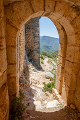Obraz premium Vertical photo of one of the entrance gates to the medieval Chirel Castle in Cortes de Pallas, Valencia, Spain, on a hill with intense natural light