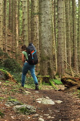 Female Hiker with Paragliding Gear Walking Up Forest Trail