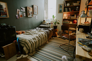 Messy male room in dormitory fully equipped with furniture and personal stuff