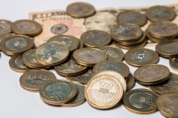 ten dollar bill and coins of one thousand Colombian pesos