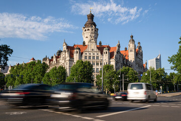 Obraz premium New town hall of the city of Leipzig. Historicism building with an imposing town hall tower. Slow shot with traffic in the foreground. New town hall is the seat of the city administration.