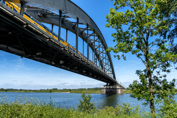 The Kuilenburgse train bridge with passing train, in Culemborg, The Netherlands in perspective