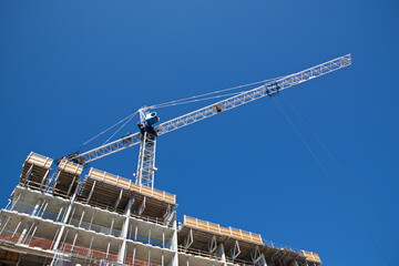 Crane and building construction site with the blue sky