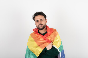 Studio shot of man holding LGBT rainbow flag