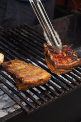 Marinated pork ribs are cooked on the coals of barbecue