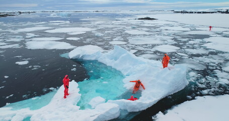People on large floating ice iceberg in Antarctica. Scientists from polar station expedition...