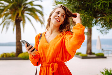 Attractive young woman tourist  walking on city street using smartphone mobile phone, Outdoors browsing internet, searching. Technology and lifestyle travel trip and journey concept.