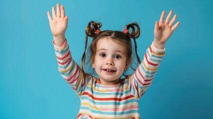 A young child holds her hands up in excitement or celebration, possibly during a special event or achievement