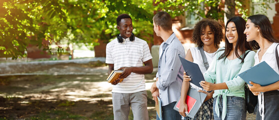 Portrait Of Smiling International Students Standing Outdoors At Campus Courtyard After Classes