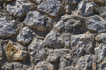 fence real stone wall surface with cement as background.