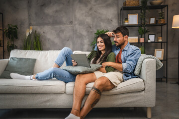 Obraz premium Girlfriend watch movie on tablet with her sleepy boyfriend
