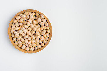 Chickpeas in a wooden bowl on a light background. Vegetarian products..