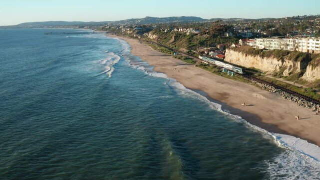 Cinematic Tilt Up Over Blue San Clemente Water as Train Travels North