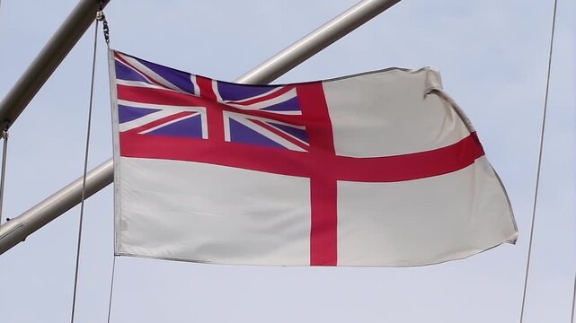 A British naval ensign on a warship of the Royal Navy., the naval flag of the United Kingdom. The flag features the Union Jack in the canton, with a red St. George's Cross.