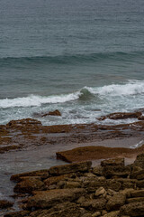 Majestic coastal cliffs with layered rock formations and lush greenery overlooking the sea in Cantabria, Spain. Perfect for landscape, travel, and nature themes.