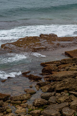 Majestic coastal cliffs with layered rock formations and lush greenery overlooking the sea in Cantabria, Spain. Perfect for landscape, travel, and nature themes.