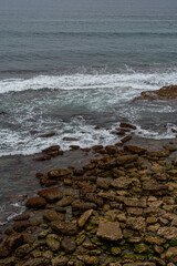 Majestic coastal cliffs with layered rock formations and lush greenery overlooking the sea in Cantabria, Spain. Perfect for landscape, travel, and nature themes.