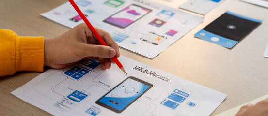 Panorama banner of startup company employee planning on user interface prototype for mobile application or website in office. UX UI designer brainstorm user friendly interface plan. Synergic