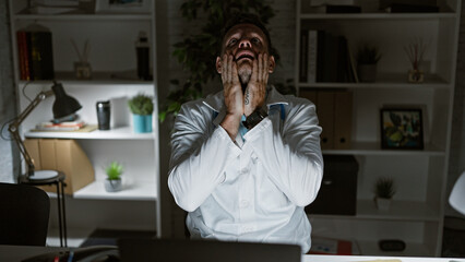 Stressed hispanic man in a white lab coat feeling exhausted at a hospital workplace with bookshelves and a desk © Krakenimages.com