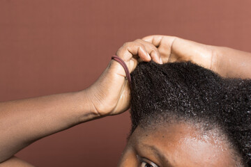 woman stretching her curly hair to emphasize shrinkage, 4c hair stretched to show shrinkage