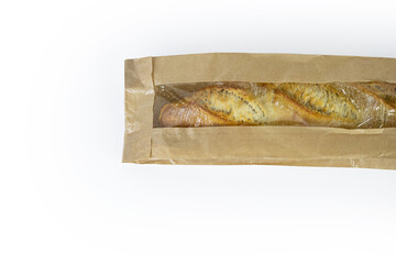 Freshly baked French baguette in a brown paper bag isolated on a white background.Loaf of white...