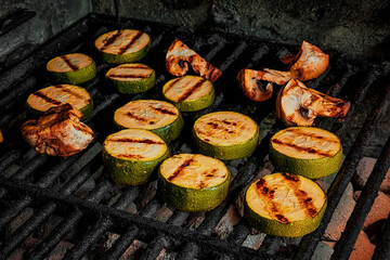 Grilled vegetables with mushrooms, herbs and spices. Summer barbecue and fresh vegetables, zucchini and mushrooms on the grill. Family weekend with barbecue and roasting vegetables