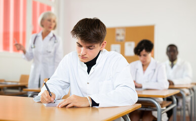 Fototapeta premium Doctors different age sitting at desk in classroom working during lesson at adult education class