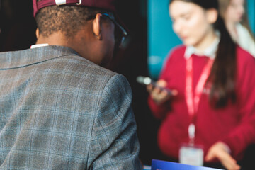 Process of checking in on a conference congress forum event, registration desk table, visitors and attendees receiving a name badge and entrance wristband bracelet and register electronic ticket