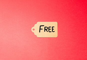 kraft paper label with the word “FREE” on a vibrant red background. Promotional tag. Shopping and black friday concept.