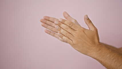 Close-up of two clapping hands against a soft pink background, capturing a sense of celebration or approval.