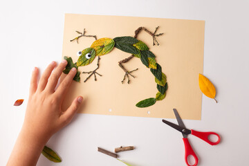 autumn nature craft for kid, lizard made of dry leaf, top view, activity for children,
