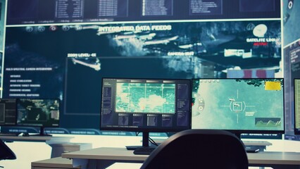 Government anti terrorism operation room equipped with a big display and surveillance on satellite radar cctv used for reconnaissance. Empty military command center with high tech.