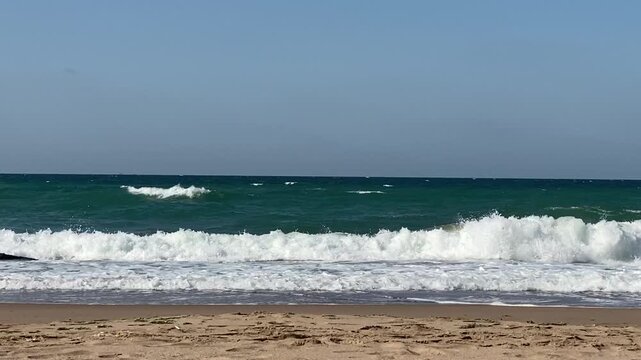 Sea waves crash on the beach.