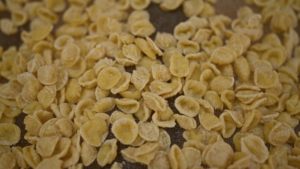 A close-up view of freshly made orecchiette pasta drying outdoors in bari, puglia, italy, showcasing the traditional italian culinary craftsmanship.