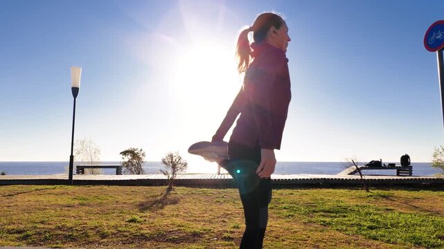 RT MS Adult woman stretching in front of the Rio de la Plata. Sun backlight. Camera orbits around her