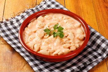 homemade chicken stroganoff in ceramic bowl on rustic wooden table