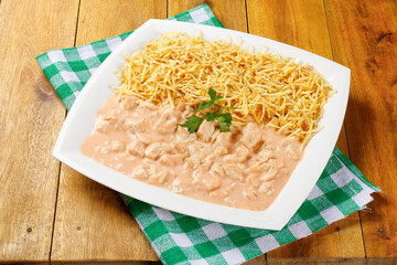 Homemade chicken stroganoff in ceramic plate on red checkered tablecloth