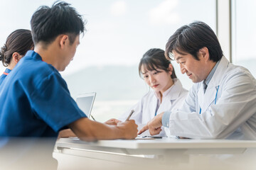 Obraz premium 真剣な表情でカンファレンスを開く男女の医療スタッフ 