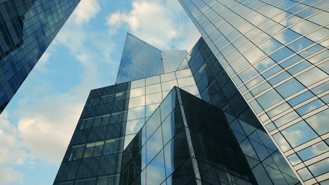 Glass skyscrapers in urban cityscape reflect sky, creating futuristic corporate setting