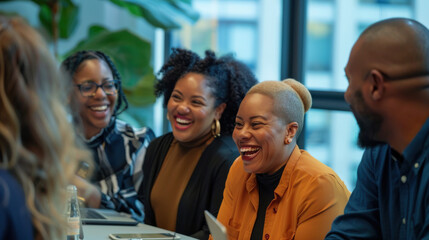 Fototapeta premium Diverse office team laughing and talking during a productive meeting, creating a positive work environment