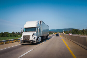 White 18-wheeler semi-truck on the highway delivering freight